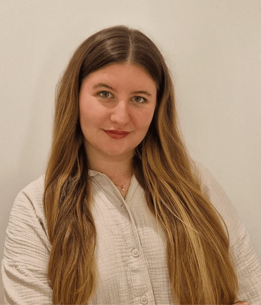 A woman with long hair is looking at the camera.