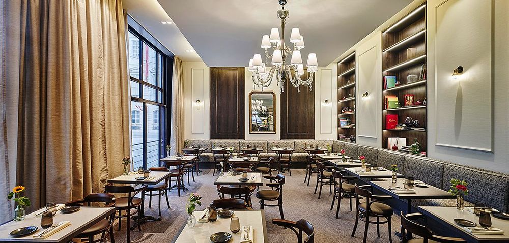 Ein geräumiges, elegantes Restaurantinterieur mit ordentlich angeordneten Tischen und Stühlen,…