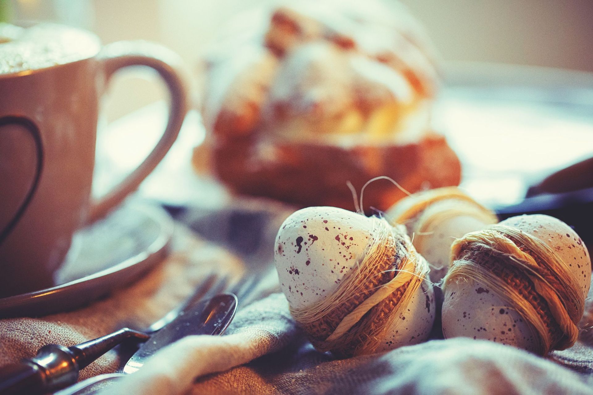 Das Foto zeigt eine Nahaufnahme von dekorativen Eiern, die mit Schnur umwickelt sind, einen…