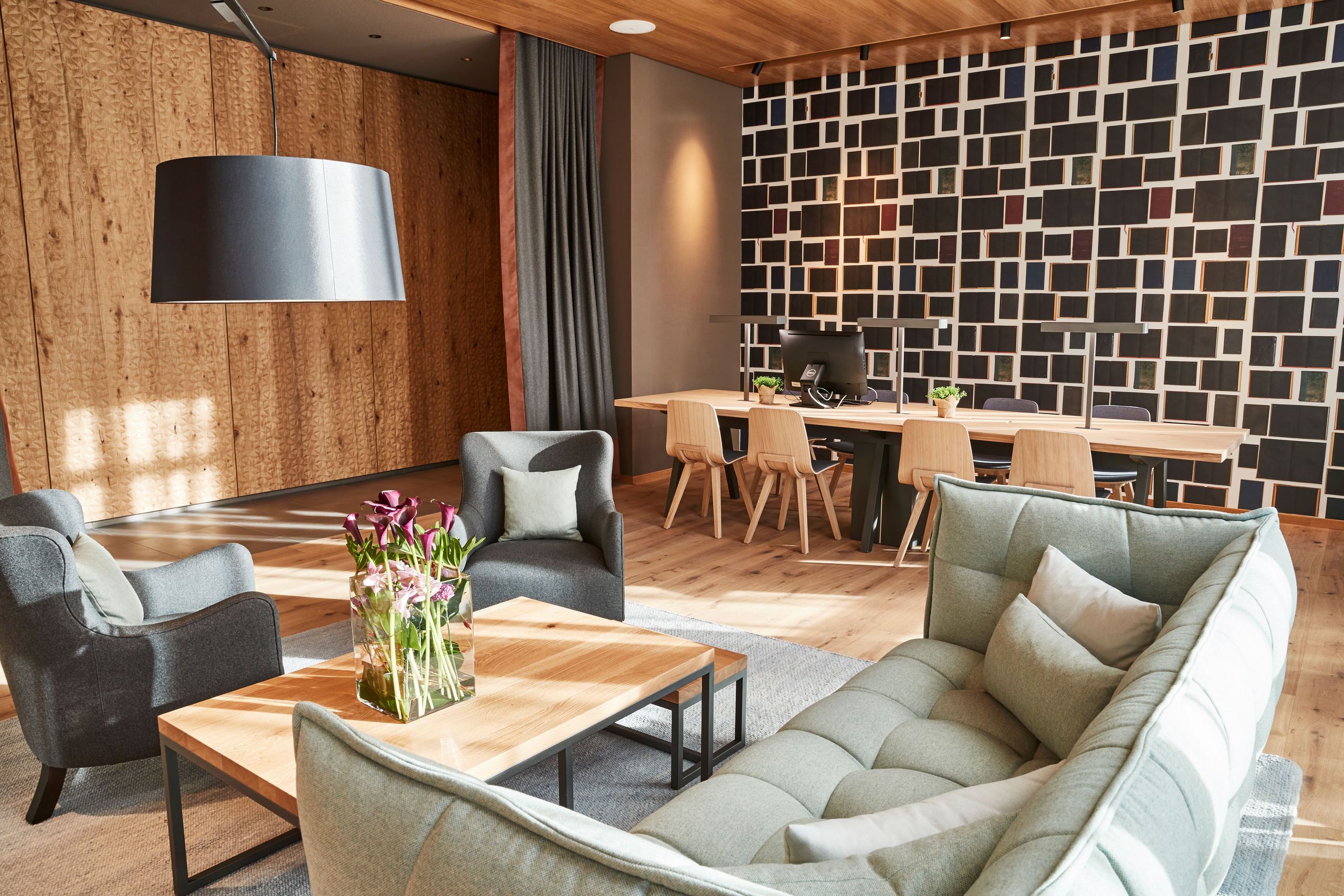 Das Foto zeigt einen modernen Wohnbereich mit Sofa, Stühlen, einem Couchtisch, einer großen…