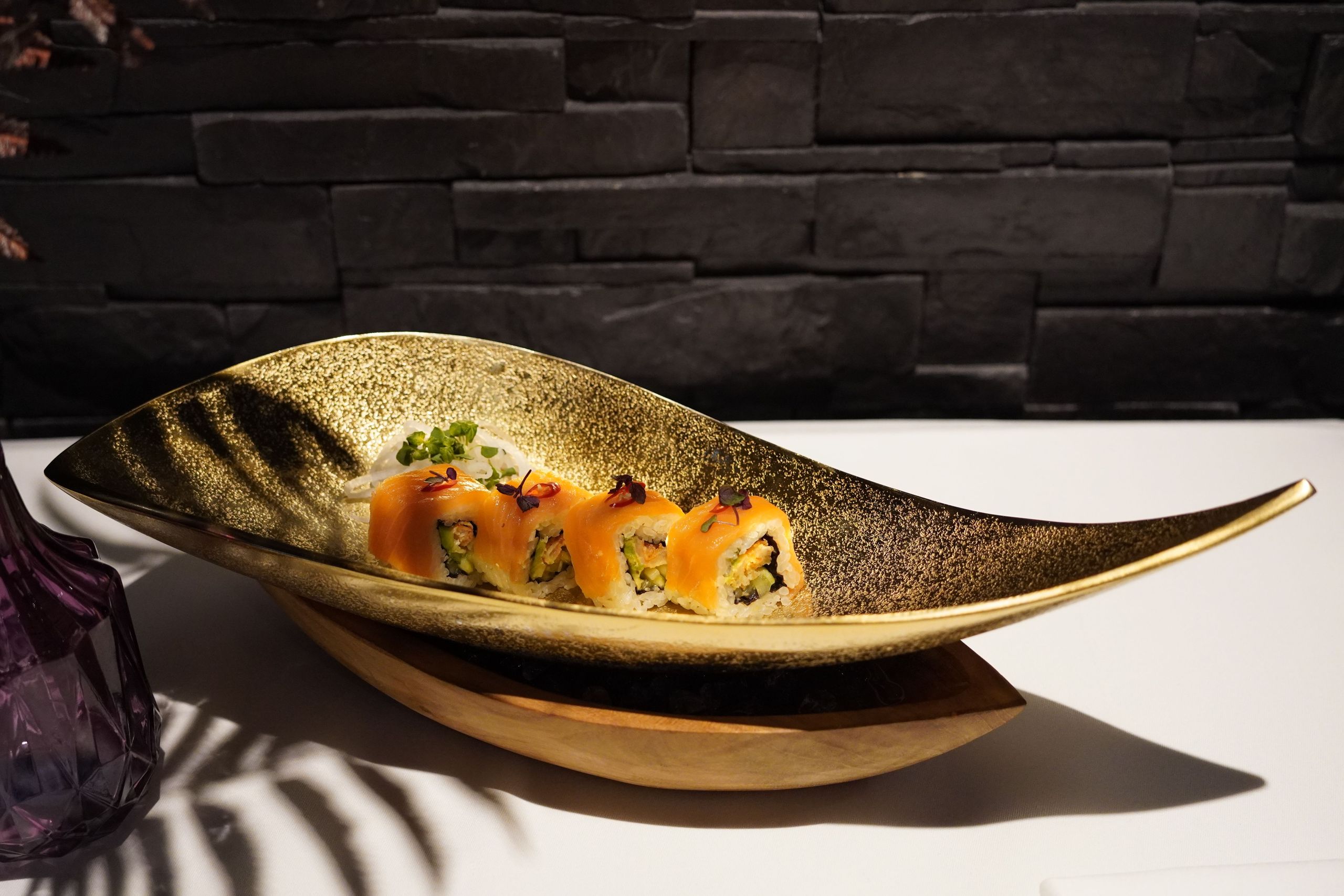 Ein Teller mit Sushi-Rollen, serviert auf einem künstlerisch geformten Teller.