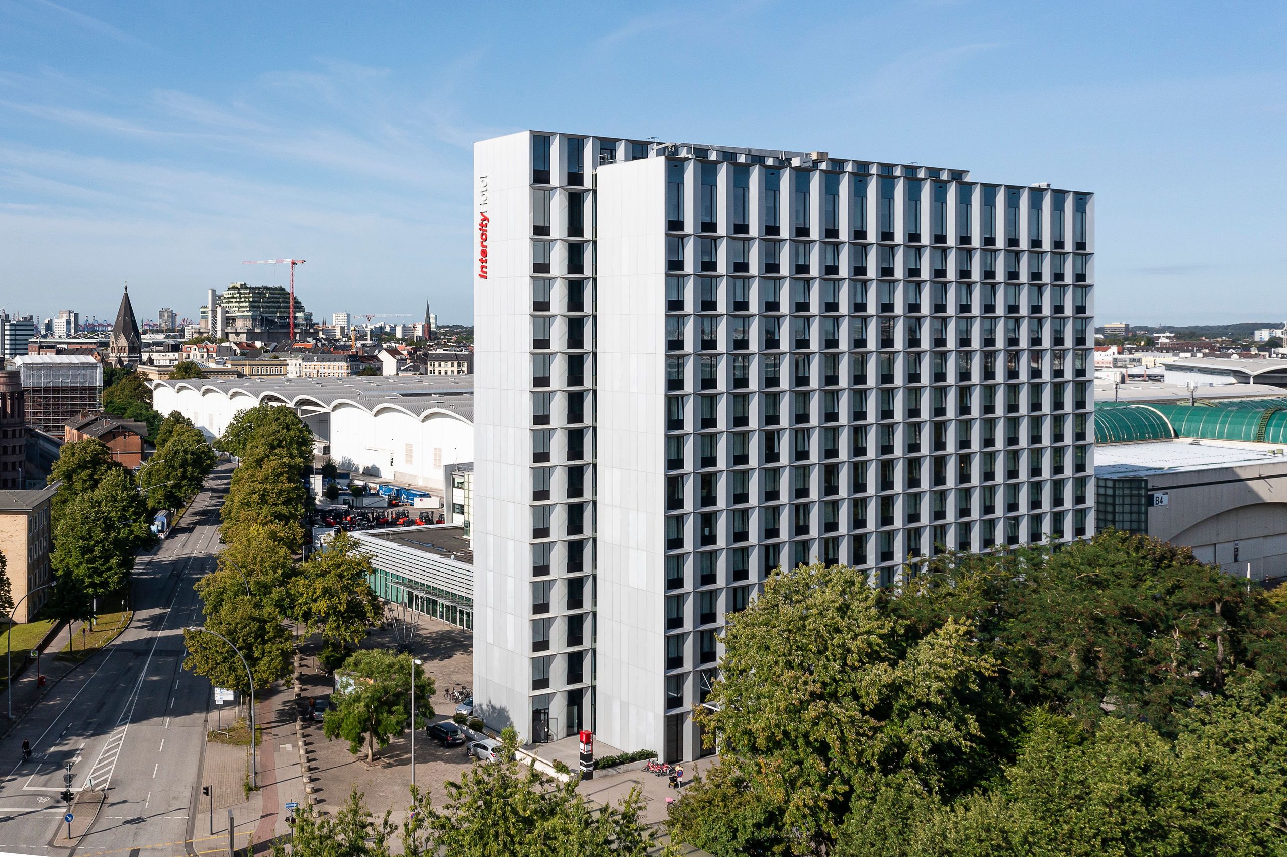 Een hoog, modern kantoorgebouw met een stadsgezicht op de achtergrond.