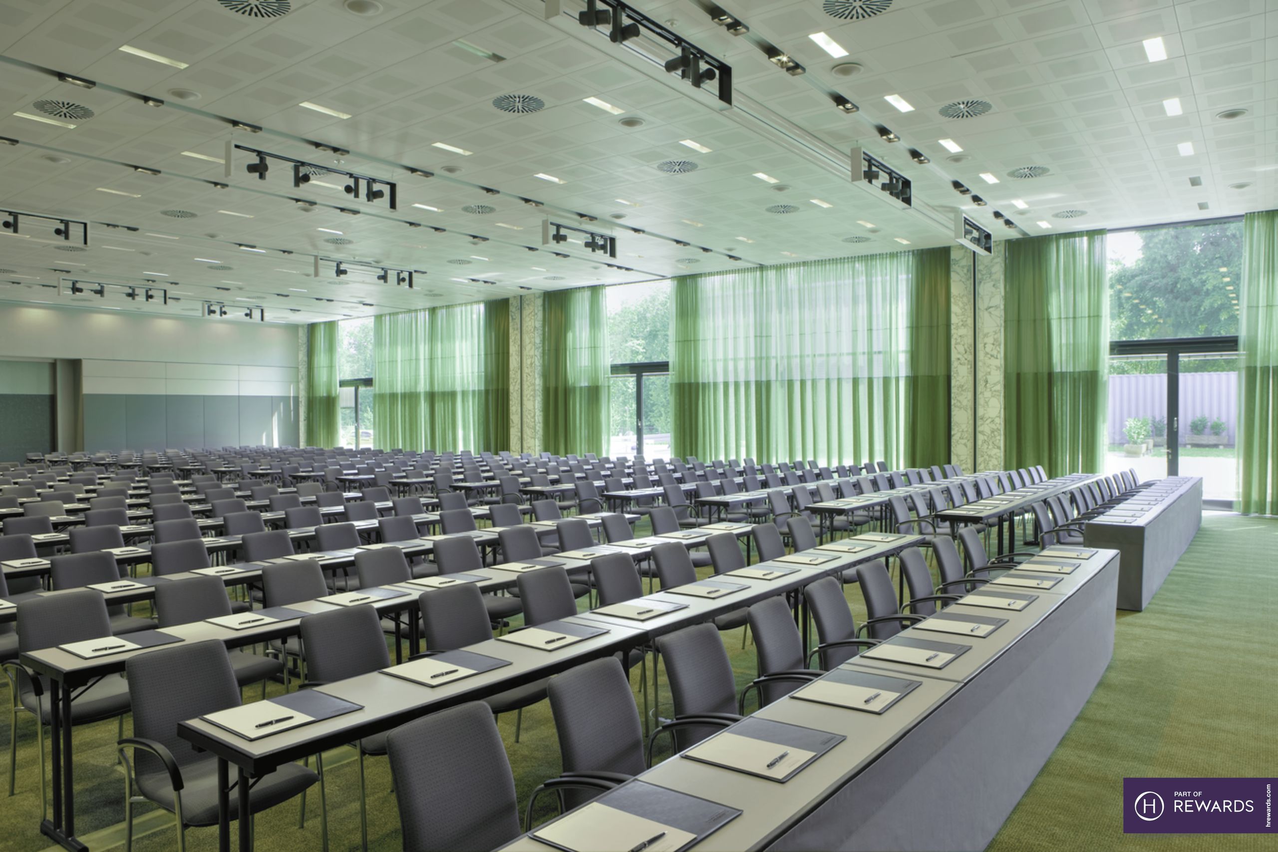 A large conference room with rows of tables and chairs arranged for a meeting or seminar.