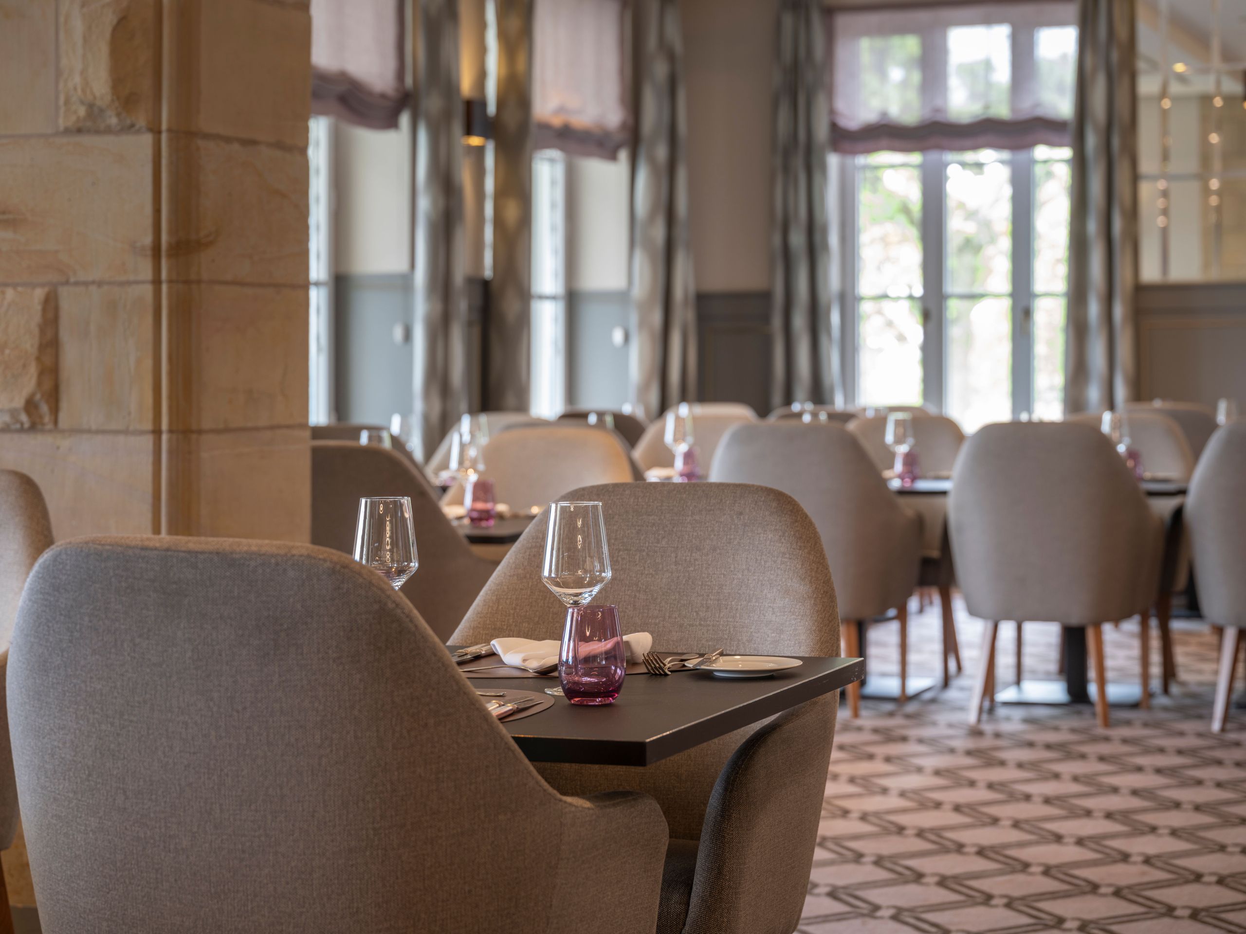 An empty restaurant dining area with neatly arranged tables and chairs.