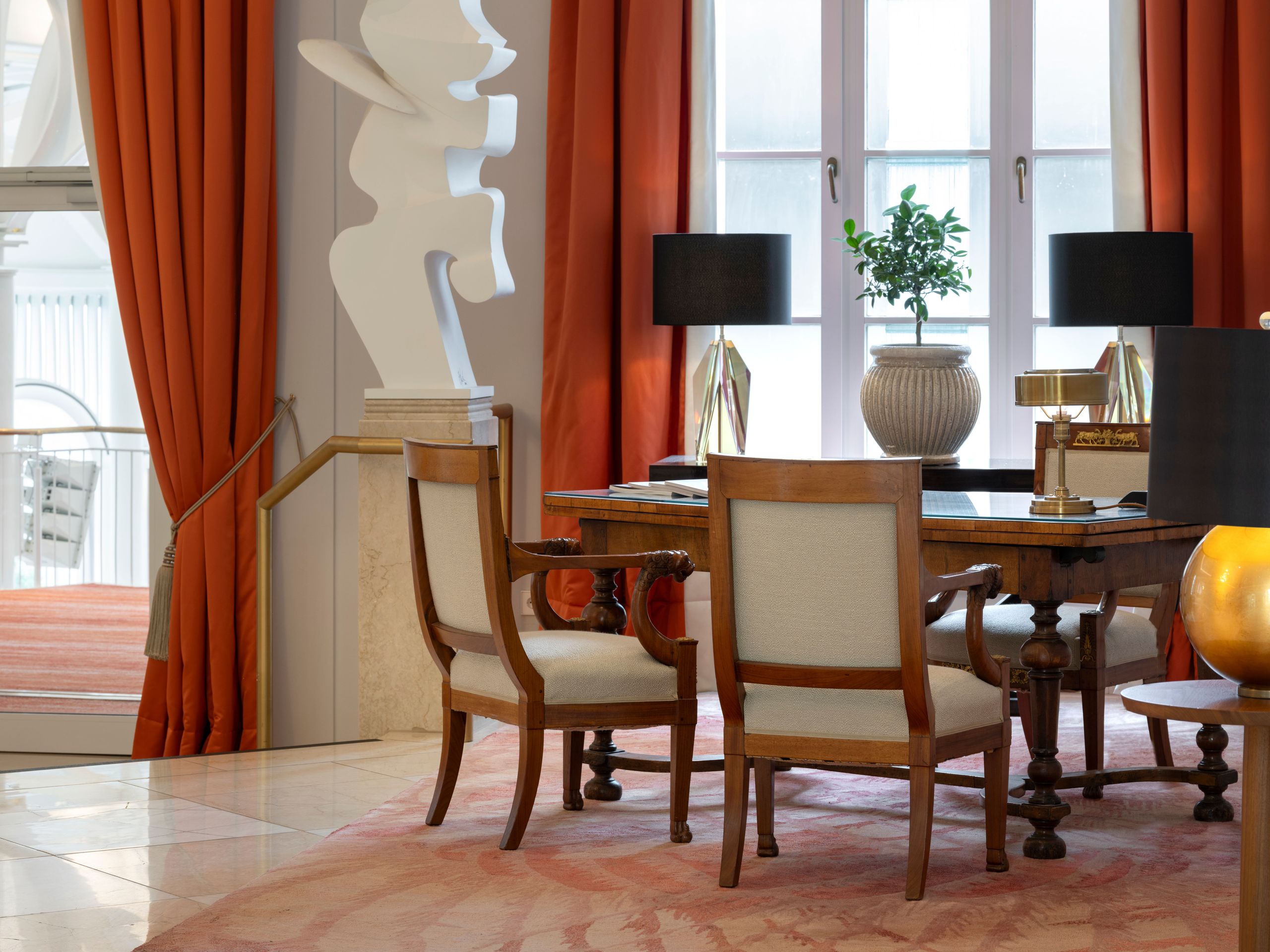 La photo montre une pièce bien meublée avec une table, des chaises, une plante, des lampes et de…