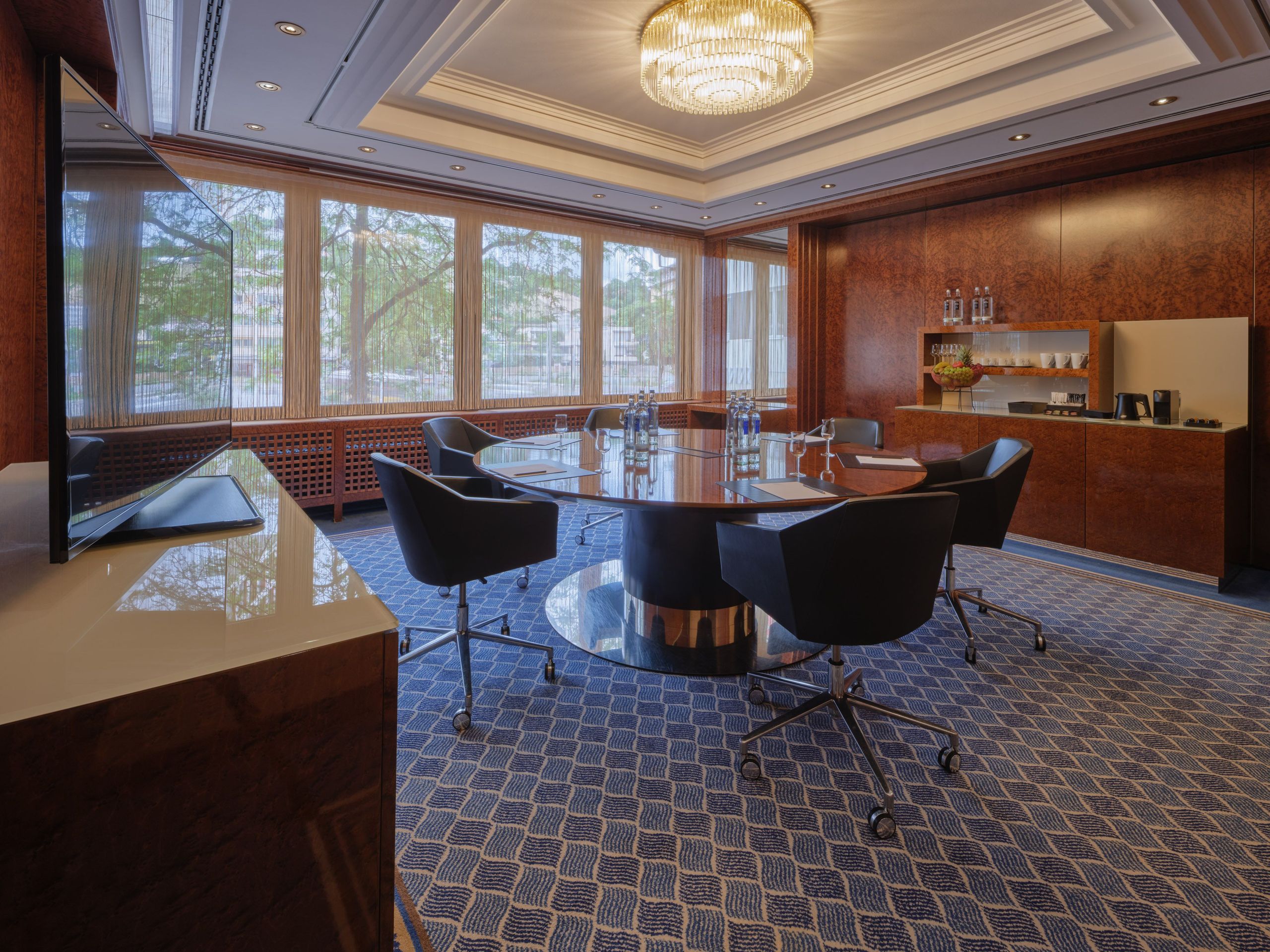 The photo shows a modern conference room with a round table and several chairs.