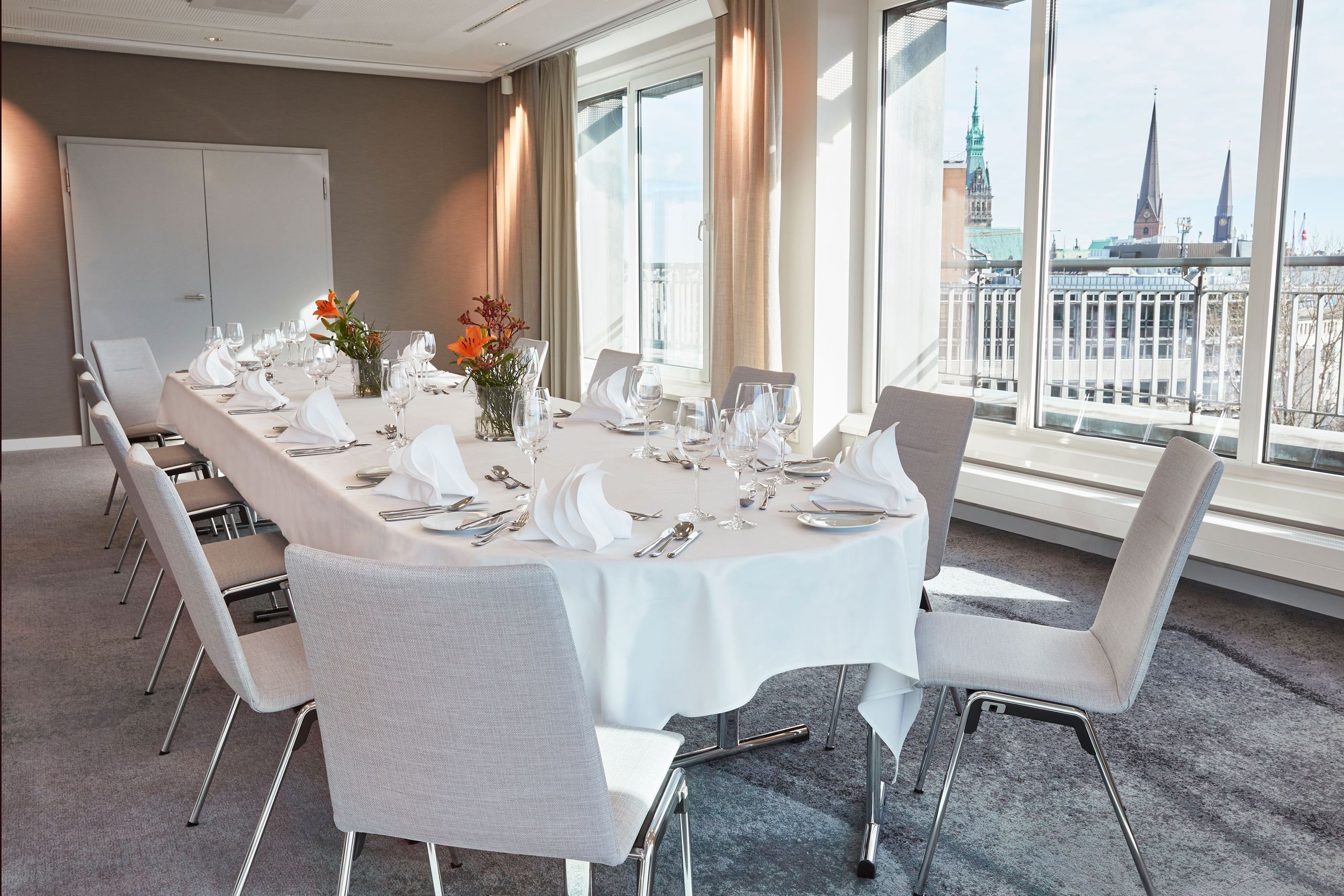 Столовая с длинным столом, накрытым для еды, аккуратно расставленная посуда, бокалы, приборы и…