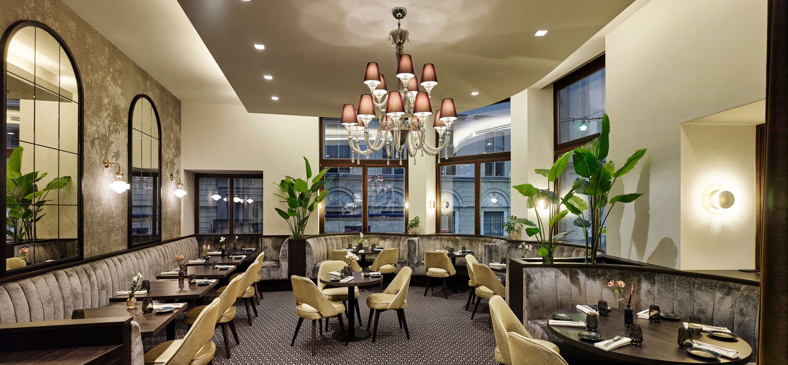 Das Foto zeigt ein stilvolles und gut beleuchtetes Restaurantinterieur mit Tischen, Stühlen,…