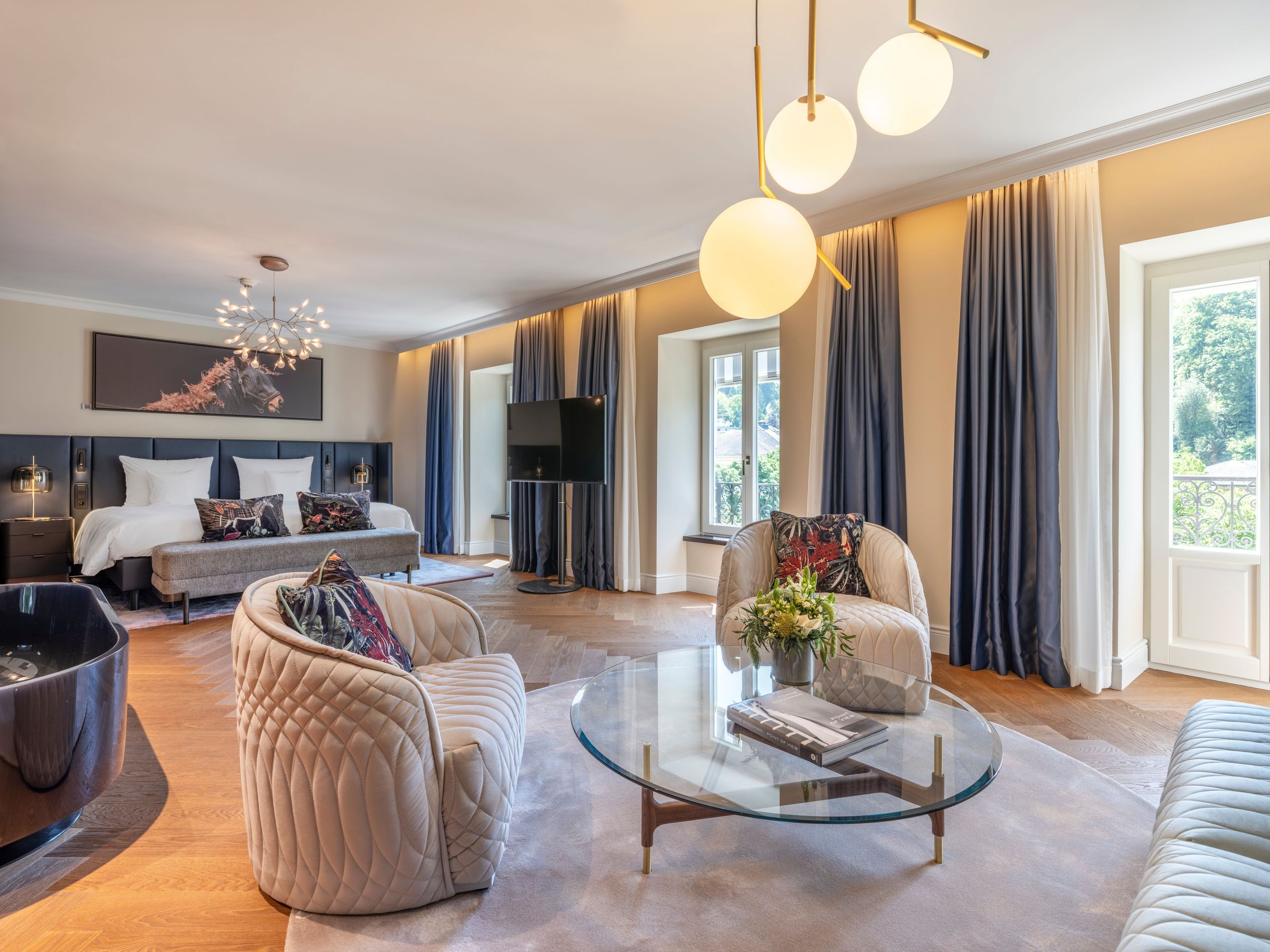 Просторная и элегантно обставленная гостиная с зонами для сидения, стеклянным кофейным столиком,…