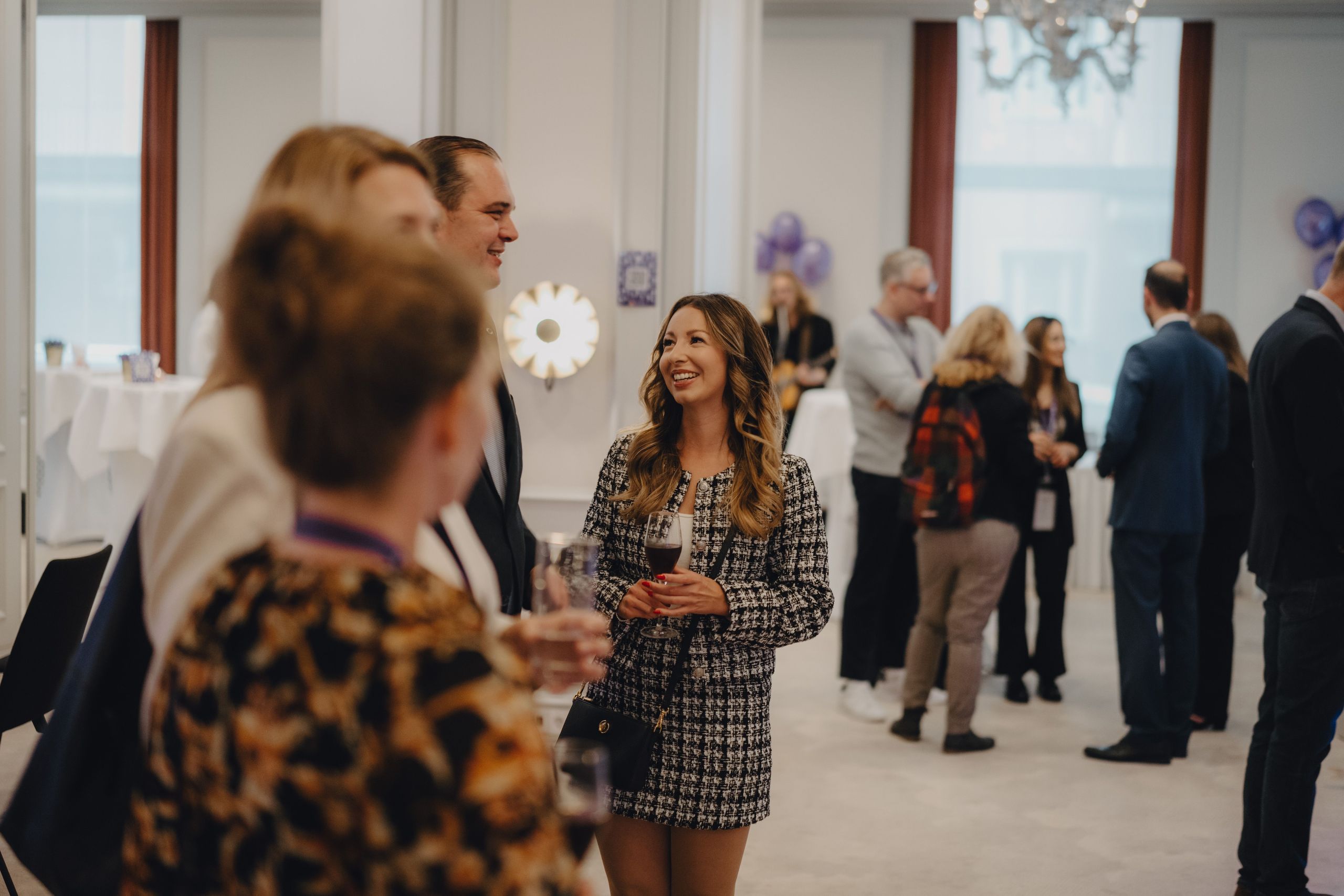 A group of people socializing at an indoor event or gathering.