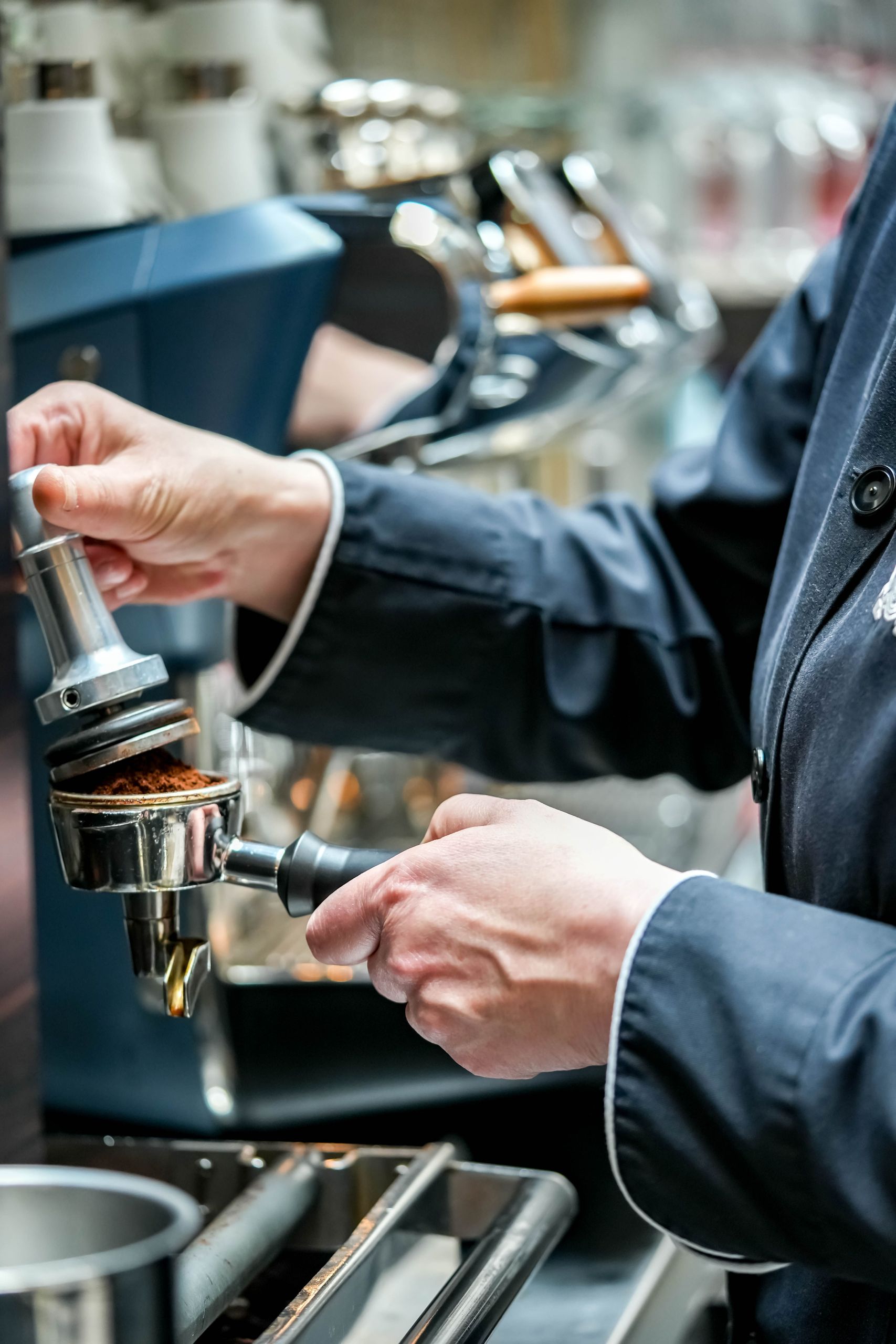 A person is preparing coffee using an espresso machine.