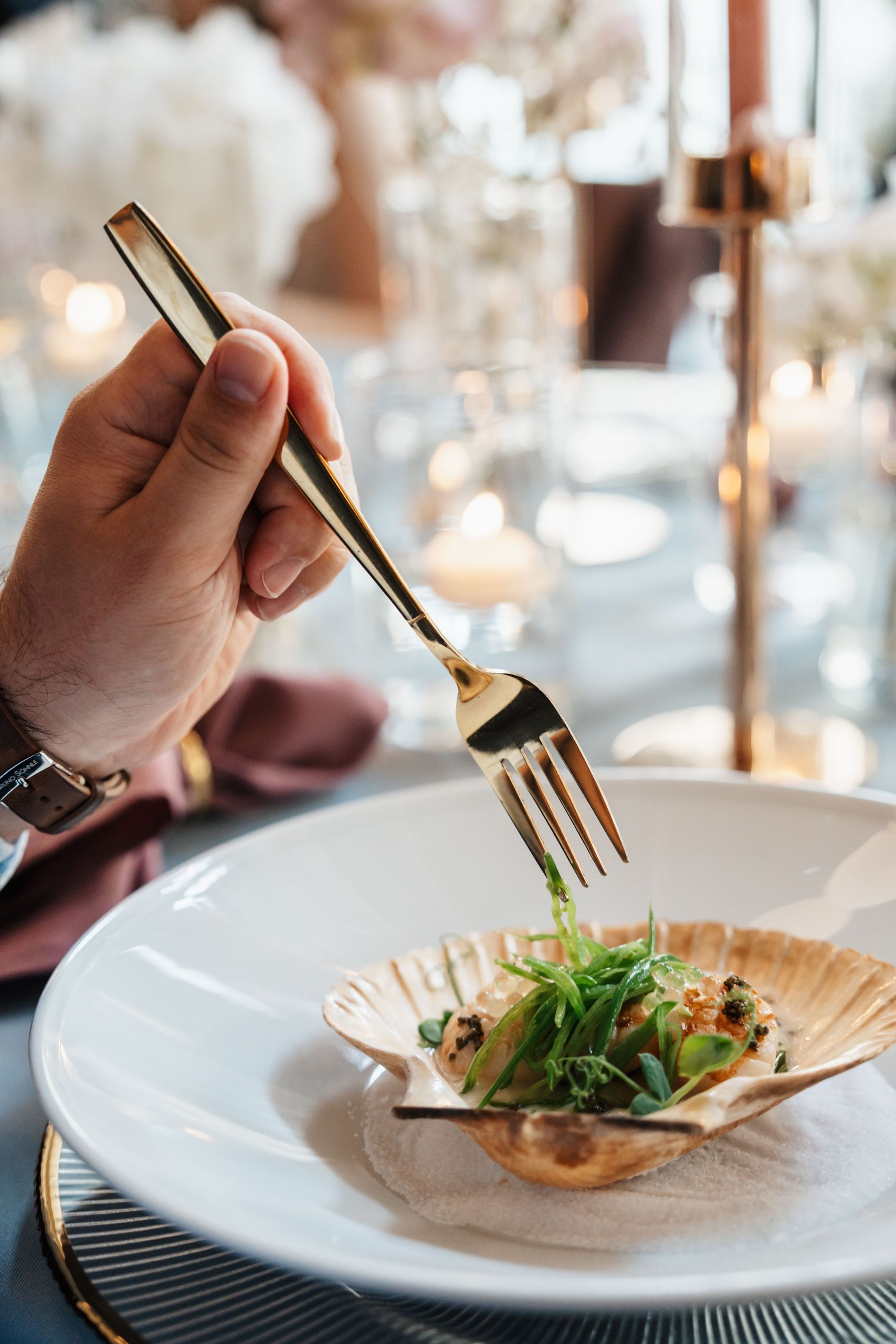 Eine Person hält eine Gabel und ist dabei, ein Gericht zu essen, das in einer Schale auf einem…