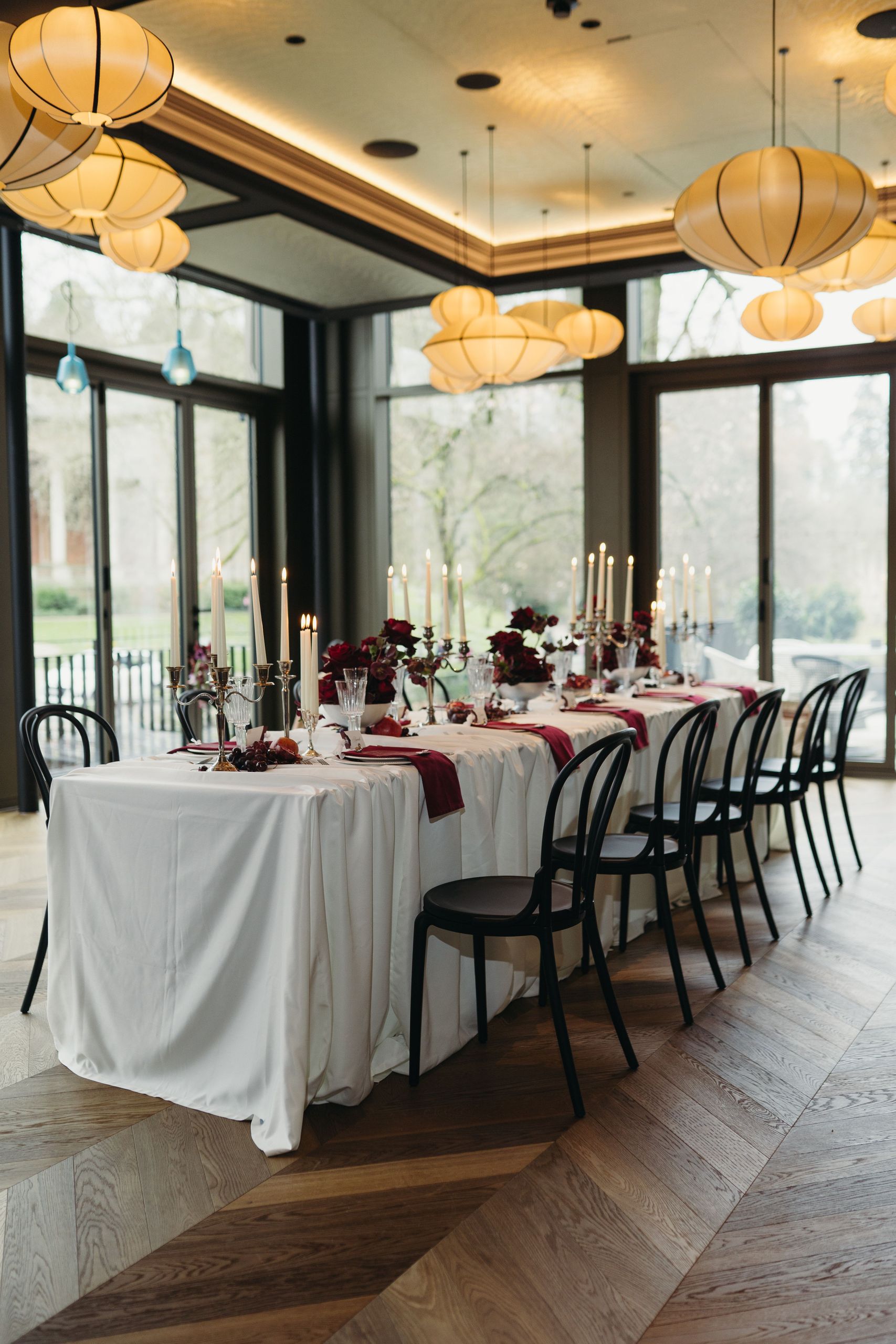 Обеденный стол, накрытый для мероприятия, с креслами, свечами и цветочными украшениями в хорошо…