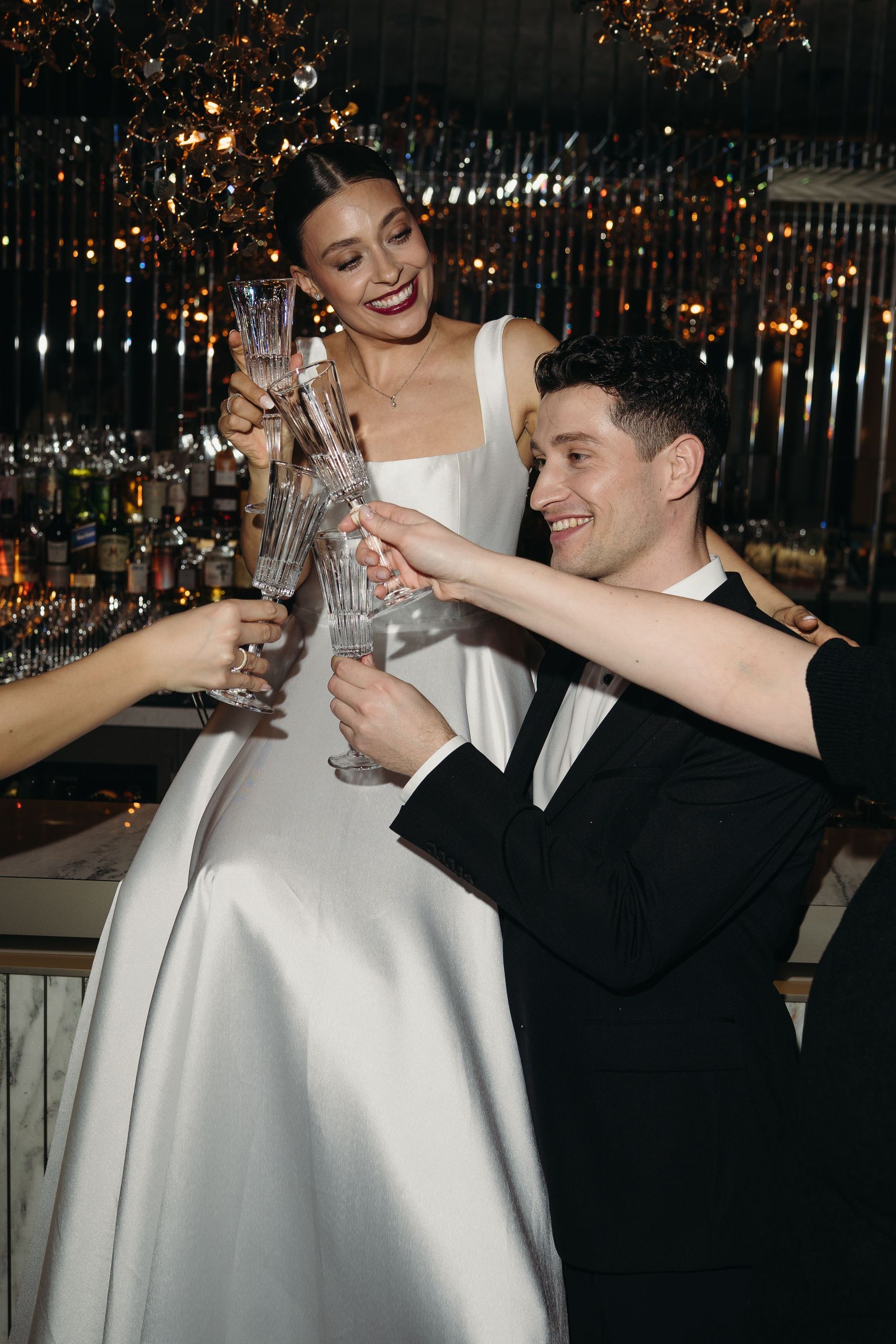 Группа людей в официальной одежде поднимает бокалы за встречу на общественном мероприятии.