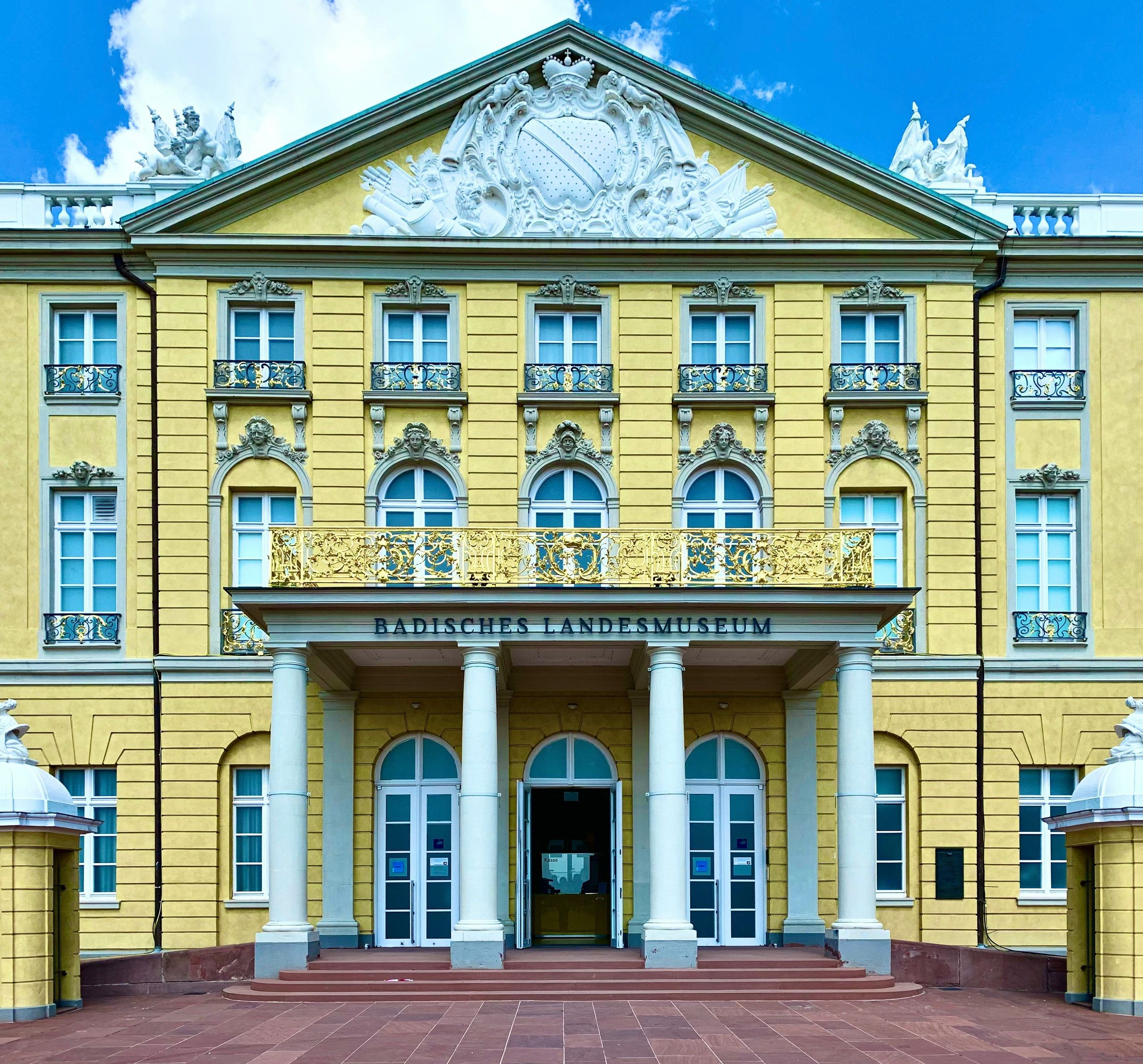 Das Foto zeigt die Fassade eines großen historischen Gebäudes mit der Aufschrift Badisches…