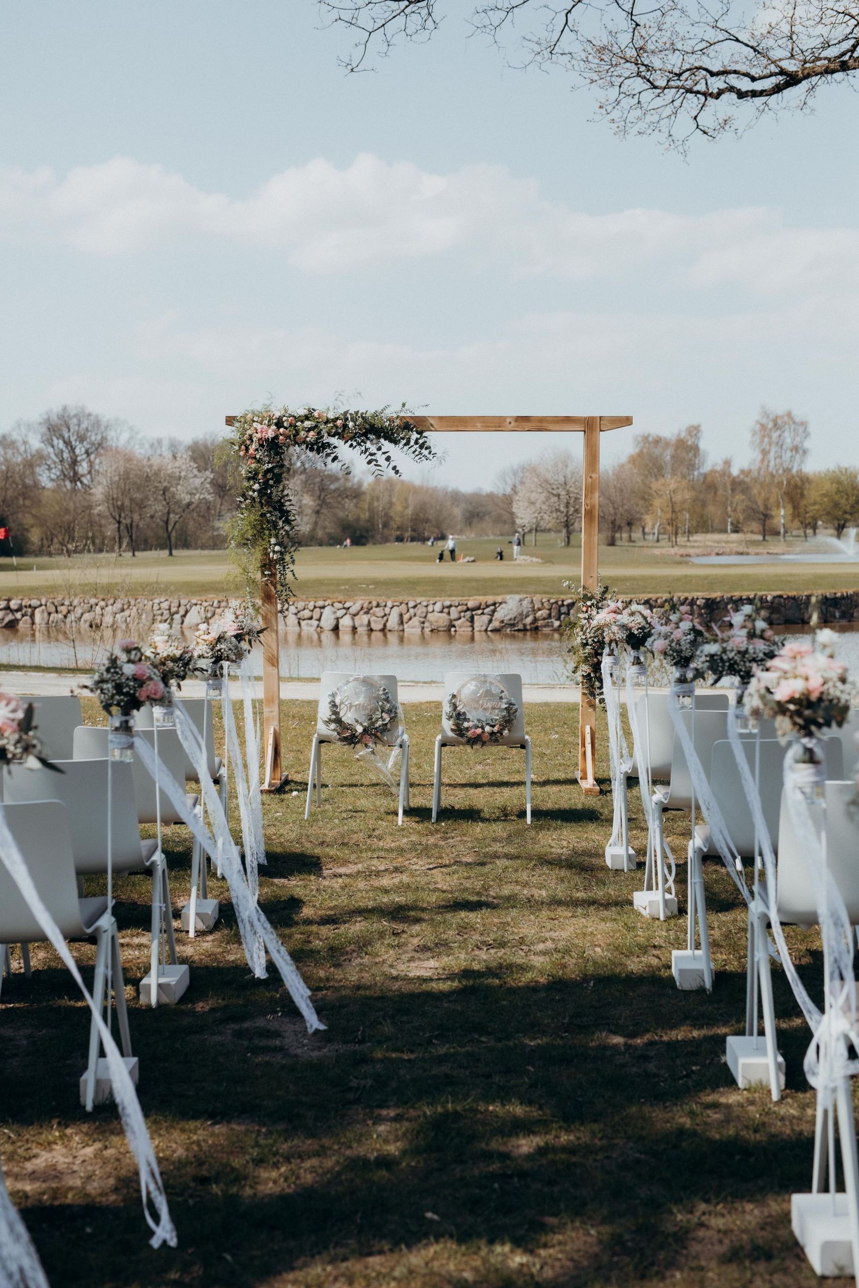 Une installation de cérémonie de mariage en plein air avec des chaises disposées en rangées,…